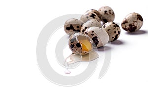 Quail eggs isolated on a white background. One egg is broken