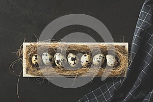 Quail eggs lined up in a row in wooden crate
