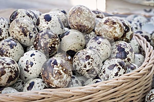 Quail eggs a lot of in basket and heap shell quail eggs on sackcloth of the wooden background