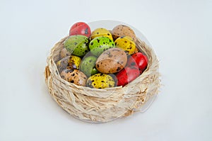 Quail eggs painted in different colors in a light wicker basket