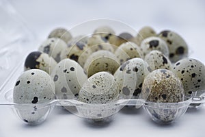 Quail eggs in plastic packaging. Quail eggs on a white background. A delicious snack