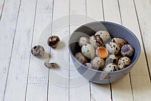 Quail eggs in a plate on a wooden background.