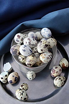 Quail eggs with plates and towels on wood table