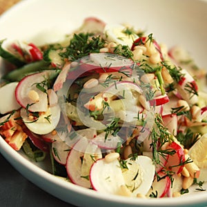 Quail eggs salad in the white bowl. Close up.