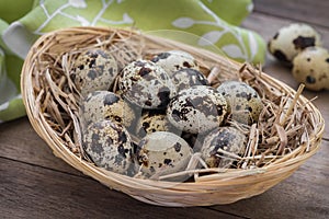 Quail eggs with straw in basket