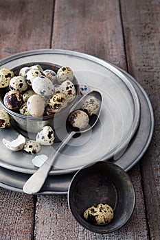 Quail eggs in tin bowl on wood table