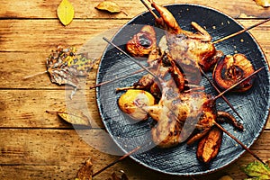 Quail fried on skewers with apples
