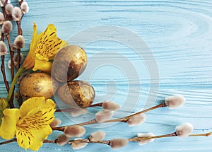 Quail golden eggs, willow on a blue wooden background decoration