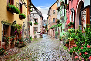 Colorful cobblestone lane in the Alsatian town of Riquewihr, France