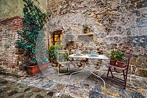 Quaint corner with table and chairs in Monteriggioni