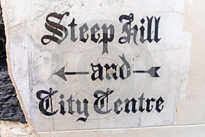 Quaint historic stone carved sign on a wall in Lincoln,  UK directing people down Steep Hill