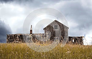 Quaint old abandoned wood house sitting in tall grass