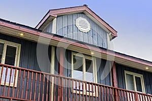 Quaint painted country house with wooden siding and large balcony