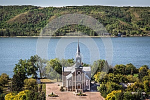 Quaint stone church sitting next to a blue lake