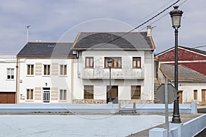 A Quaint Town Square Featuring an Old White Building with a Red Roof