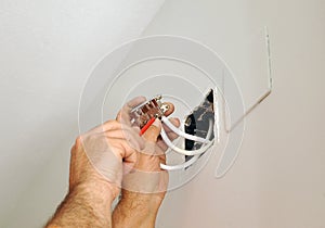 A qualified electrician doing the wiring connections to the television antenna in the junction box for the renovation of the house