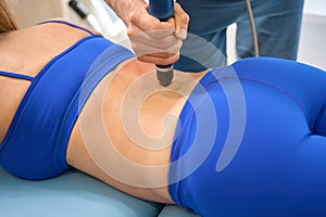 Qualified physiotherapist conducting extracorporeal shockwave therapy