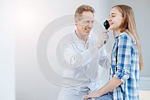 Qualified smiling doctor using dermatoscope at work