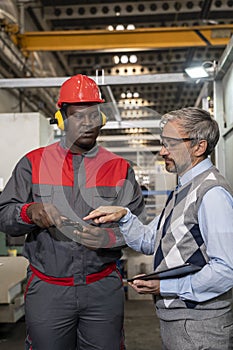 Quality Control Inspector With Digital Tablet Talking To African American CNC Machine Operator