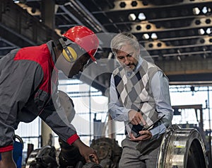 Quality Control Inspector Using Digital Tablet And Talking To African American Worker At Train Factory