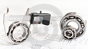 Quality control in modern mechanical engineering - caliper gauges, technical drawing and ball bearings on white background