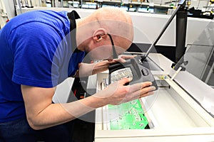 Quality control in the production - man checks board for defects