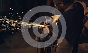 Quality craftsmanship like youve never seen before. a man using an angle grinder while working at a foundry.