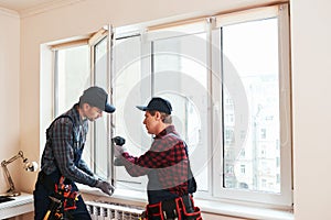 Quality light. Construction workers installing new window in house