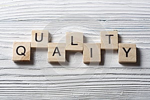 QUALITY word written on wood abc block at wooden background