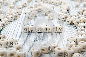 QUALITY word written on wood block. Wooden ABC