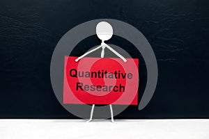 Quantitative research concept. Human stick figure holding red placard paper with written text. photo