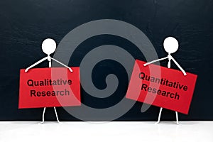 Quantitative vs qualitative research concept. Human stick figure holding red placard paper with written text. photo