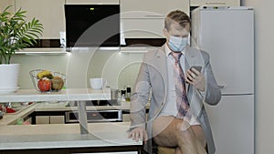 Quarantine. Businessman in mask working on phone at home office. Coronavirus