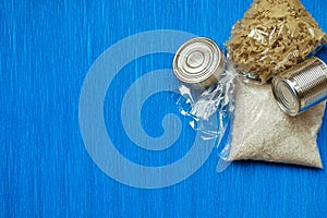 Quarantine food stock on blue background. Canned food, cereals. Delivery. Donation. Copyspace