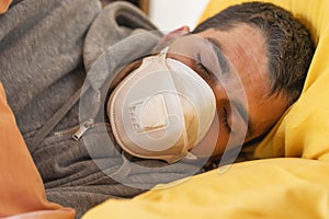 Quarantine oubreak Coronavirus. Sick man of corona virus lying down in bed wearing mask protection mask and recovery from home