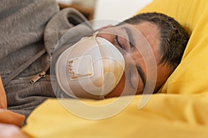 Quarantine oubreak Coronavirus. Sick man of corona virus lying down in bed wearing mask protection mask and recovery from home