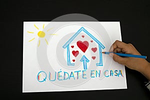 Quarantine in Spain. Kid hand draw picture with spanish words Quedate en casa - Stay at home photo