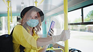 Quarantine travel, cute attractive girl enjoys public transport ride, takes precautions and wears medical mask and