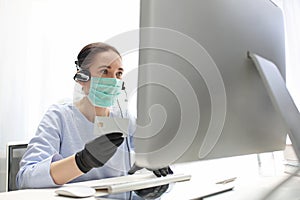 Quarantine. Working at the computer in a mask. protection of employee health.