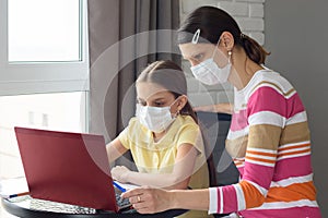 Quarantined girl and girl perform school tasks online photo