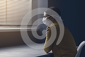 Quarantined woman with covid-19 wearing a face mask photo