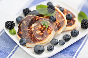 Quark cheese fried cakes with blueberry. Traditional Russian sweet syrniki. photo