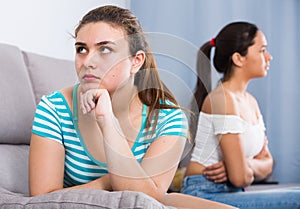 Quarreled girls apart on couch