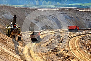 Quarry excavator loading sand or into dump truck at opencast