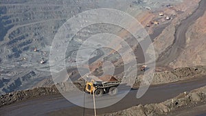 Quarry with ore. Works appliances. Excavators and BelAZ. In the frame, BelAZ passes, filled with ore.