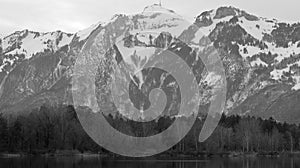 Quarry pond with forest and mountains in background in black and white