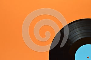 Quarter black vinyl record on orange background