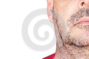 A quarter of the face of a middle-aged man with a week`s worth of beard. Unshaven face with Space for text on white background