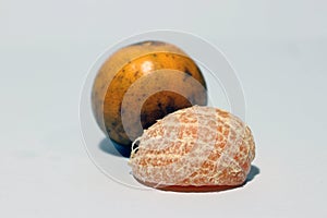 Quarter of peeled orange and one orange does not peel isolated on white background.