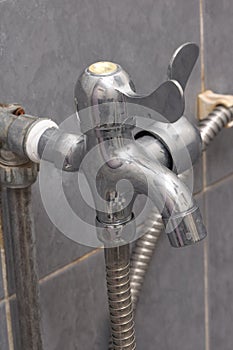 A quarter turn two way tap faucet grey tiles backdrop